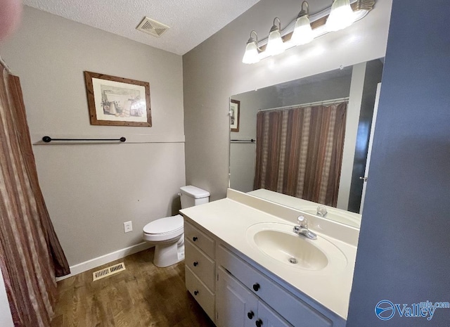 full bath with visible vents, a textured ceiling, toilet, and wood finished floors