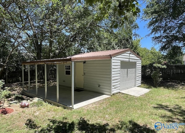 view of outdoor structure with fence and an outbuilding