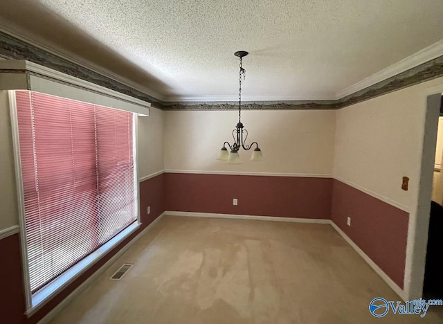 unfurnished dining area with carpet, visible vents, a textured ceiling, and ornamental molding