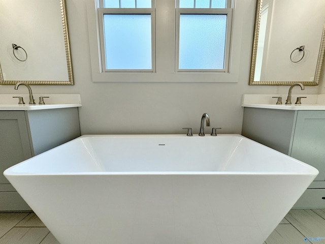 bathroom with vanity, a tub to relax in, and a wealth of natural light