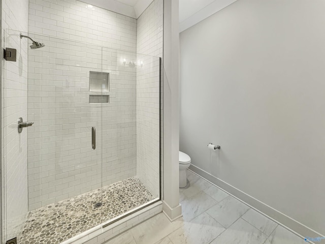 bathroom featuring a shower with door and toilet