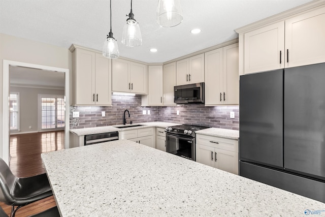 kitchen featuring sink, refrigerator, pendant lighting, electric stove, and a breakfast bar