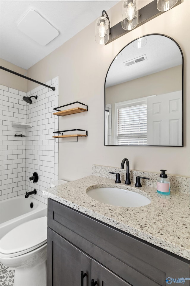 full bathroom with toilet, tiled shower / bath combo, and vanity