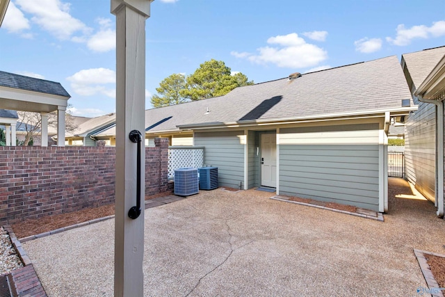 rear view of property with a patio area and central AC