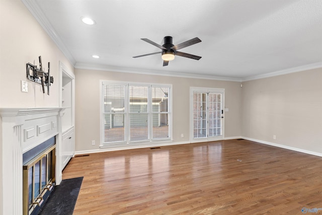 unfurnished living room featuring ceiling fan, ornamental molding, and wood-type flooring