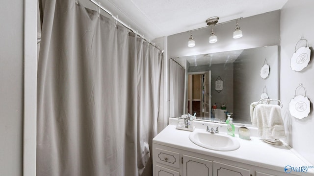 bathroom featuring curtained shower and vanity