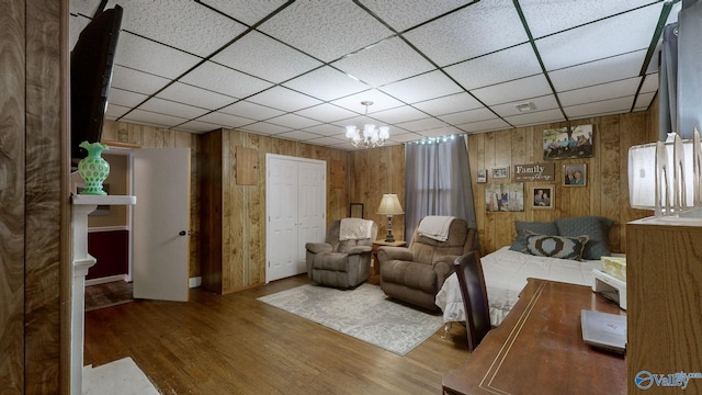 sitting room featuring wood walls, dark hardwood / wood-style flooring, and an inviting chandelier