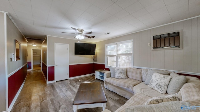 living room with hardwood / wood-style floors, ceiling fan, and crown molding