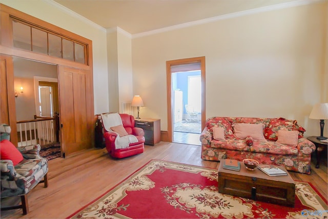 living room with light wood-type flooring and crown molding