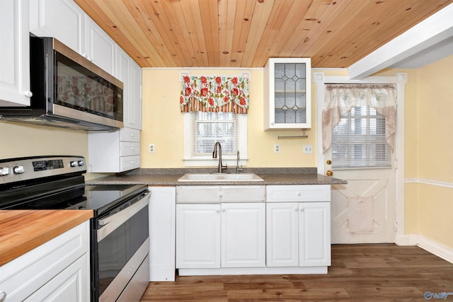 kitchen with dark wood-type flooring, a sink, white cabinetry, appliances with stainless steel finishes, and wooden ceiling