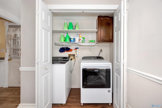 laundry room with cabinet space, separate washer and dryer, and wood finished floors