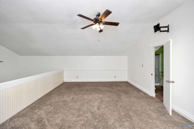 bonus room with baseboards, ceiling fan, vaulted ceiling, carpet floors, and a textured ceiling