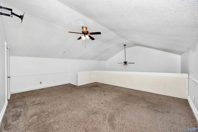 bonus room featuring a textured ceiling, carpet, a ceiling fan, and vaulted ceiling