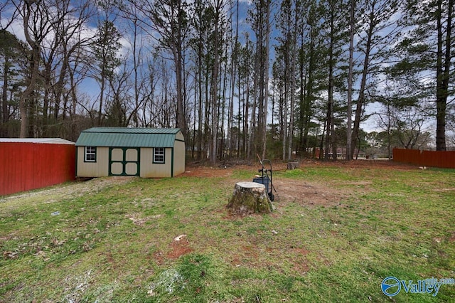 view of yard featuring an outdoor structure, a storage unit, and fence