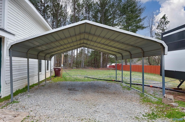 view of parking / parking lot with a detached carport and fence