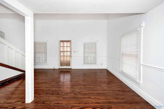 interior space with a textured ceiling and wood finished floors