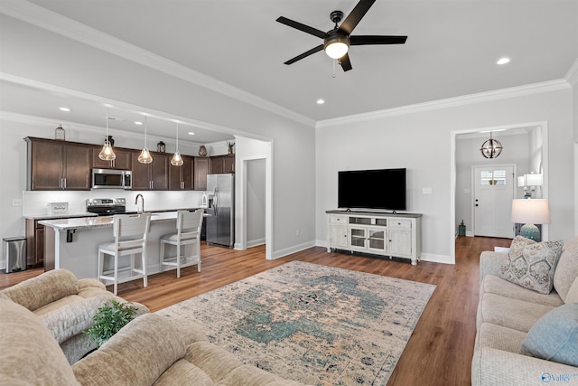 24009 Quints Dr, Athens, AL 35613 - living room featuring a ceiling fan, crown molding, baseboards, light wood finished floors, and recessed lighting