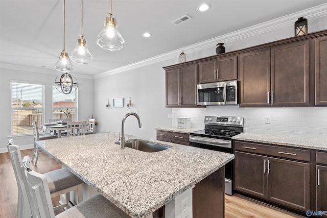 24009 Quints Dr, Athens, AL 35613 - kitchen with appliances with stainless steel finishes, a sink, light wood-style flooring, light stone counters, and backsplash