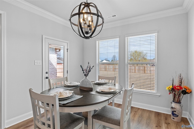 24009 Quints Dr, Athens, AL 35613 - dining area featuring a chandelier, ornamental molding, plenty of natural light, light wood finished floors, and baseboards