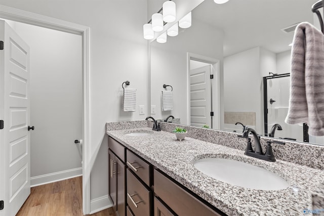 24009 Quints Dr, Athens, AL 35613 - bathroom featuring double vanity, baseboards, wood finished floors, a stall shower, and a bathtub