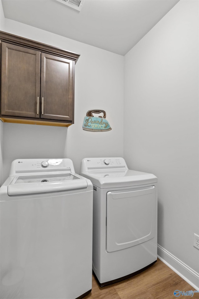 24009 Quints Dr, Athens, AL 35613 - washroom with washer and dryer, cabinet space, light wood finished floors, and baseboards