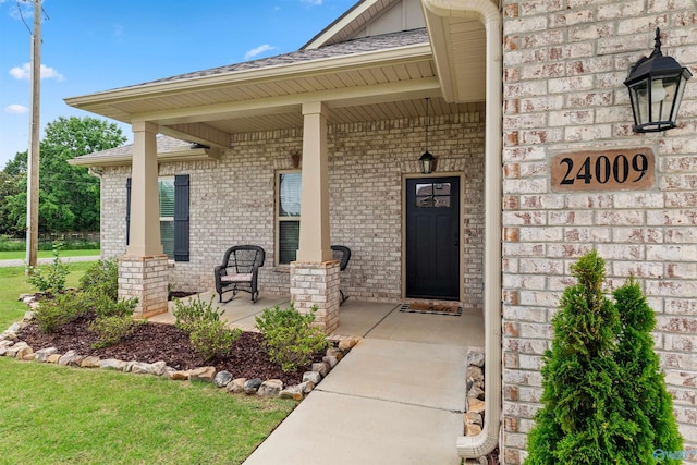 24009 Quints Dr, Athens, AL 35613 - view of exterior entry featuring brick siding, covered porch, and a shingled roof