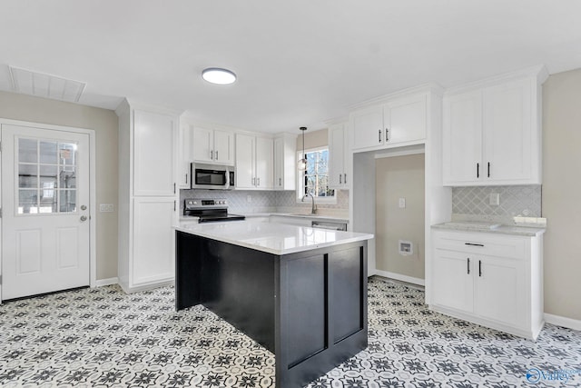 kitchen featuring white cabinetry, hanging light fixtures, stainless steel appliances, and a kitchen island