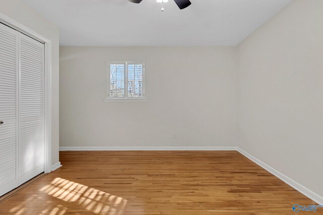 unfurnished bedroom featuring light hardwood / wood-style floors, a closet, and ceiling fan