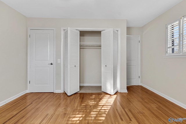 unfurnished bedroom with a closet and light hardwood / wood-style flooring