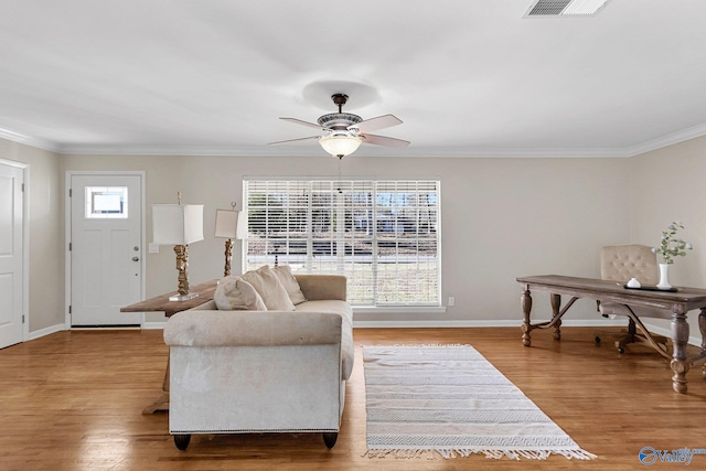 living room featuring ornamental molding, ceiling fan, and light wood-type flooring