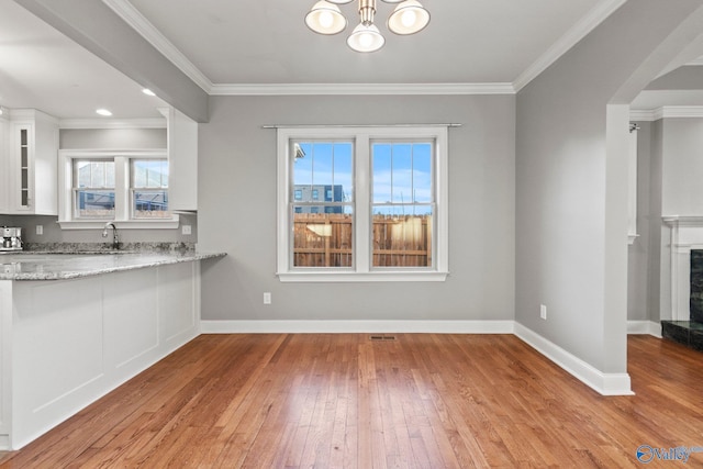 interior space with baseboards, a premium fireplace, glass insert cabinets, and white cabinets