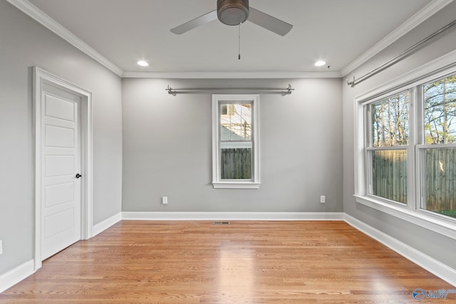 spare room featuring ornamental molding, light wood-style flooring, and baseboards