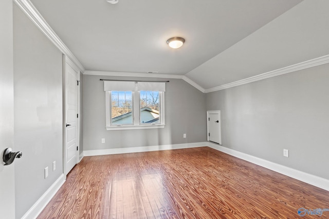 additional living space featuring vaulted ceiling, baseboards, and wood finished floors