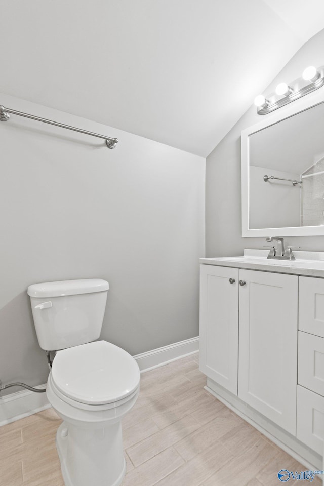 full bathroom with lofted ceiling, baseboards, vanity, and toilet