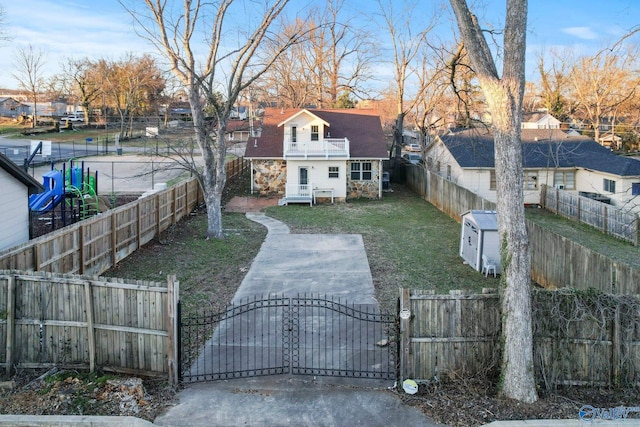 exterior space featuring a fenced front yard, a gate, a chimney, and a front lawn