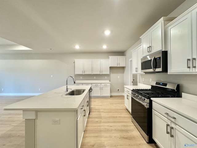 kitchen featuring white cabinetry, appliances with stainless steel finishes, and a kitchen island with sink