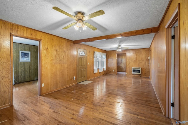 unfurnished living room with ceiling fan, heating unit, and a textured ceiling