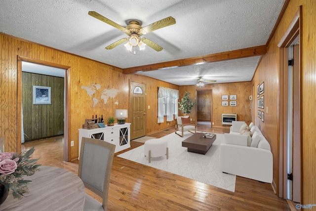 living area featuring wood finished floors, a textured ceiling, and ceiling fan