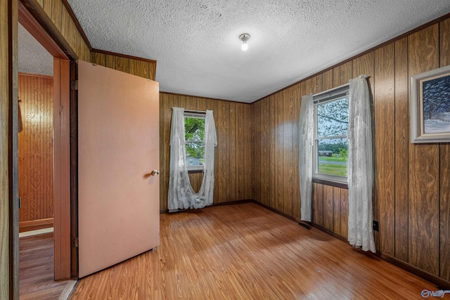 empty room featuring wood finished floors, a textured ceiling, and plenty of natural light