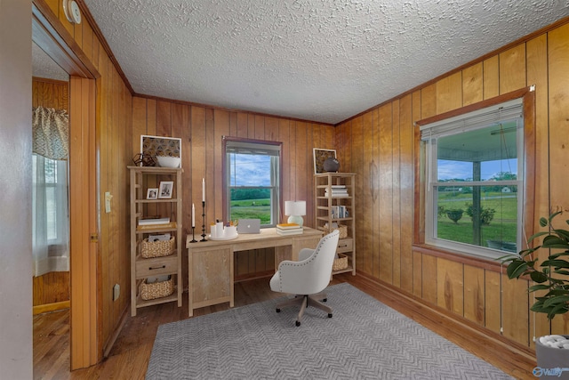 office featuring wood walls, wood finished floors, a textured ceiling, and crown molding