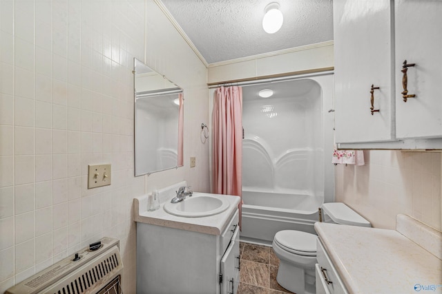 full bathroom featuring toilet, vanity, ornamental molding, tile walls, and a textured ceiling