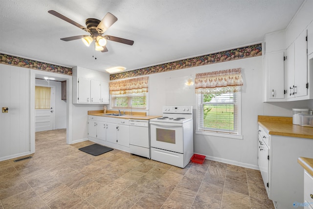 kitchen with baseboards, a healthy amount of sunlight, and white appliances
