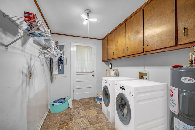laundry room featuring electric water heater, separate washer and dryer, cabinet space, stone finish flooring, and baseboards