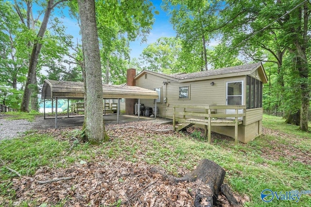 19822 Riverside St, Athens, AL 35601 - rear view of property with a carport, a sunroom, and a chimney