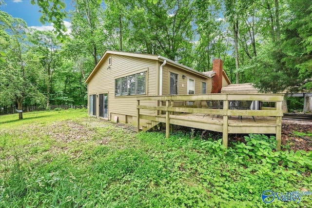 rear view of house featuring a wooden deck and a chimney