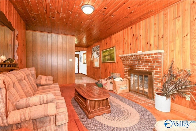 living area featuring a brick fireplace, wooden ceiling, and wood walls