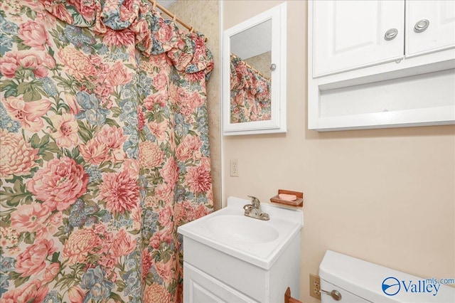 full bathroom featuring a shower with shower curtain, toilet, and vanity