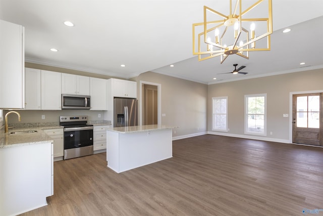 kitchen featuring open floor plan, appliances with stainless steel finishes, a kitchen island, and a sink
