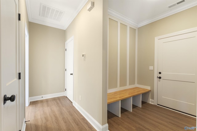 mudroom featuring wood finished floors, visible vents, and ornamental molding