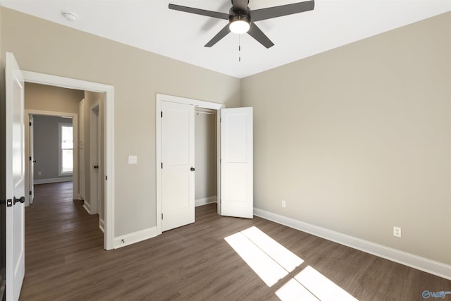 unfurnished bedroom with a closet, a ceiling fan, baseboards, and wood finished floors